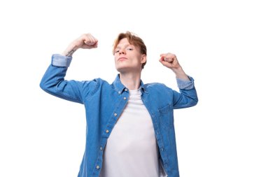 Beyaz arka planda mavi kot gömlek giymiş, altın sarısı saçlı, kendine güveni tam genç Avrupalı bir adam..