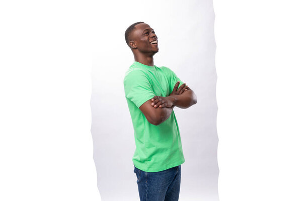 Handsome energetic 30 year old african man dressed in a light green basic t-shirt on a white background.