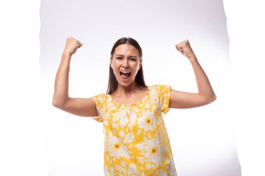 Yazın sarıya bürünmüş esmer bir kadın. Karizmatik bir şekilde yüz ifadeleri gösteriyor..