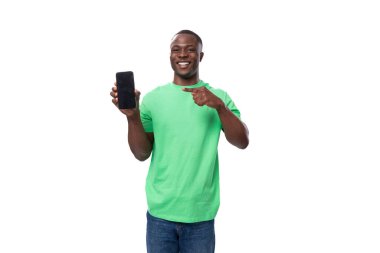 Genç Amerikalı adam yeşil şirket tişörtü giymiş akıllı telefon ekranı gösteriyor..