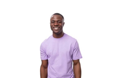 Genç, olumlu, kısa saçlı, leylak tişörtlü Amerikalı bir adam..
