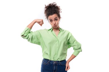 Genç, narin Avrupalı kıvırcık saçlı, at kuyruklu, kıvırcık saçlı kadın yeşil gömlek giyiyor..