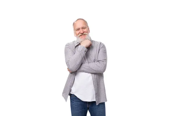 Stock image handsome gray-haired elderly man in a shirt doubts on a white background with copy space.