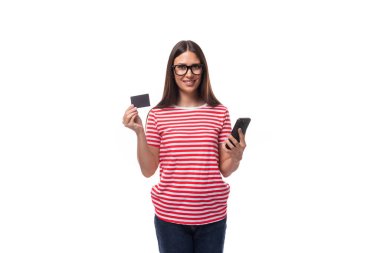 35 yaşında, kırmızı çizgili tişörtlü ve gözlüklü güzel bir Avrupalı kadın, beyaz arka planda fotokopi çekilen plastik bir kredi kartı modelini gösteriyor..