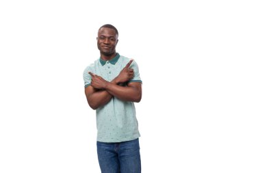 Tişört giymiş genç, narin Amerikalı bir adam elini bir reklama doğrultuyor..