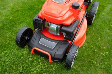 Yeşil çimlerin üzerinde dayanıklı yumuşak çim biçme makinesi.