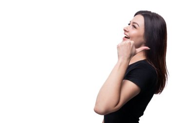 Beyaz arka planda siyah tişört giyen beyaz tenli esmer bir kadın..