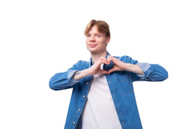 Kısa kızıl saçlı beyaz bir adam mavi bir gömlek giyiyor..