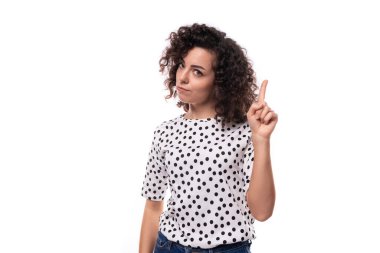 İnce, beyaz iş kadınının portresi. Kıvırcık siyah saçlı, yaz bluzu giymiş..