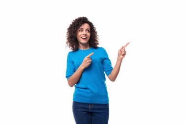 Mavi ceketli, kıvırcık saçlı genç esmer bir bayan elini ilana doğru şaşkına çeviriyor..