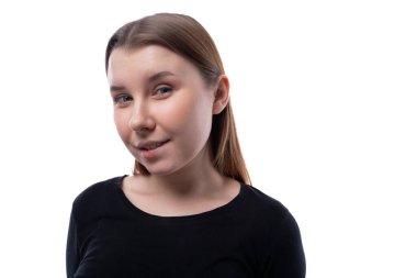 Kahverengi saçlı genç bir kız kameraya şüpheli bir şekilde bakıyor..