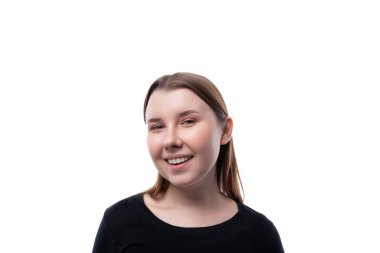 Beyaz arka planda gülümseyen, sarışın bir kızın yakın plan portresi..