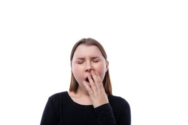 Siyah giysili tatlı okul kızı beyaz arka planda esniyor..