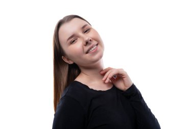 Beyaz bir arka planda kahverengi saçlı, gülümseyen komik bir okul kızının portresi..