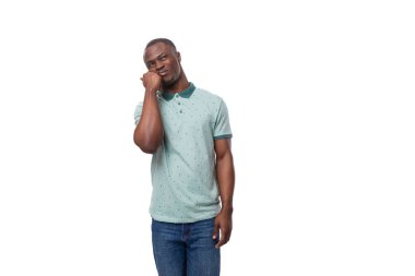 Genç, yakışıklı, gülümseyen Afrikalı bir adam. Kafasını tutarak düşünüyor..