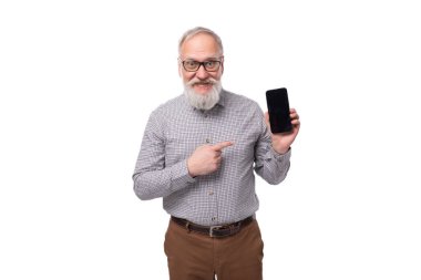 60 yaşında, bıyıklı, gözlüklü, gri sakallı yaşlı bir iş adamı akıllı telefon ekranında maketini gösteriyor..