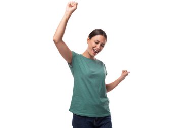 Genç, narin, esmer, beyaz kadın gündelik giysiler içinde seviniyor ve dans ediyor..