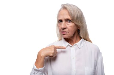 Gri saçlı Avrupalı iş kadını şüpheli görünüyor.