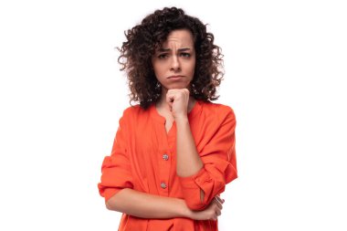 Turuncu gömlekli, kıvırcık saçlı, başarılı beyaz iş kadını..