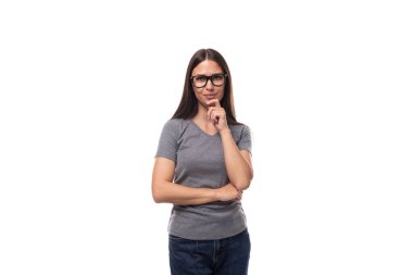 Gri, basit tişört giymiş, beyaz arka planda, fotokopi alanı olan esmer, Avrupalı genç bir kadın..