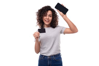 Beyaz arka planda elinde plastik kart ve akıllı telefon ekranı olan 30 yaşında beyaz bir kadının portresi. e-iş konsepti.