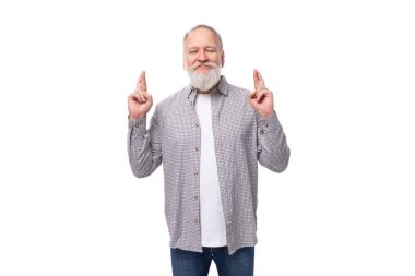 Gri sakallı ve bıyıklı son sınıf öğrencisi beyaz arka planda ekose gömlek ve kot pantolon giyiyor..