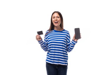 Mavi kazak giymiş oldukça ince Avrupalı model bir kadın akıllı telefon kullanarak online transferlerden hoşlanıyor. Plastik kredi kartı ve akıllı telefon tutan kadın..