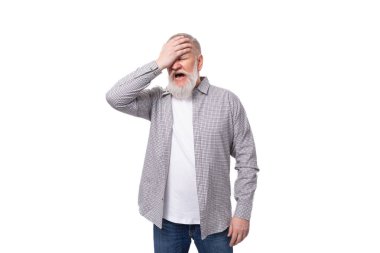 Gri saçlı, gömlekli yaşlı bir adam, beyaz arka planda, fotokopi alanı olan bir adama kızar..