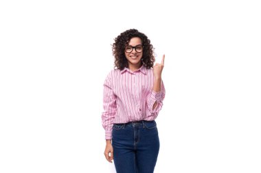 Avrupalı kıvırcık saçlı, pembe bluzlu bayan ofiste çalışıyor. Arka planda fotokopi alanı var..