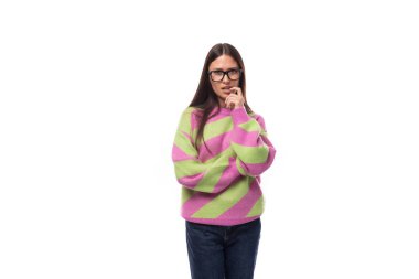 Zeki, esmer bir kadının portresi günlük tarz pembe-yeşil bir süveter giyen, beyaz arka planda görüş için gözlüklü, fotokopi alanı olan bir kadın..