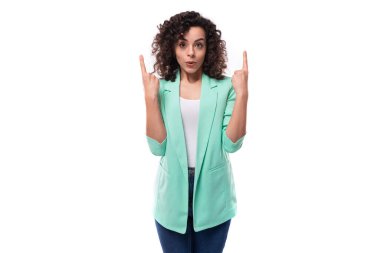 Kıvırcık siyah saçlı genç, ince, beyaz kadın model, modaya uygun mavi bir ceket giyiyor..