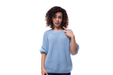 Mavi kazak giymiş genç kıvırcık esmer kadın beyin fırtınası yapıyor..