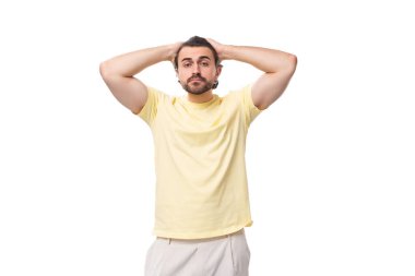 Beyaz arka planda sarı tişörtlü, esmer şık bir adam..