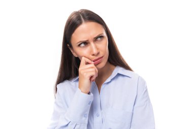 Süslü, bakımlı, beyaz saçlı, düz saçlı, mavi bluzlu bir kadının portresi. Beyaz bir arka plana dikkatlice bakıyor..