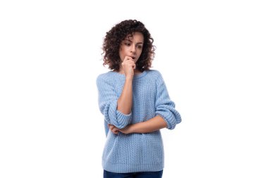 Kıvırcık, doğal, koyu renk saçlı, sıradan, mavi kazak giyen beyaz bir kadın beyin fırtınası yapıyor..