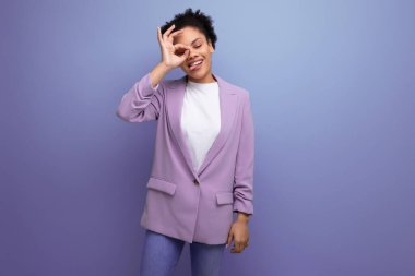 Stüdyo arka planında fotokopi alanı olan ceketli, güzel, esmer bir ofis kadını..