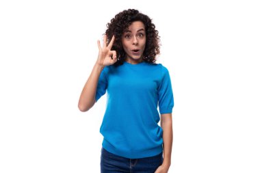 Mavi kazaklı genç kıvırcık kadın iyi bir jest yapıyor..