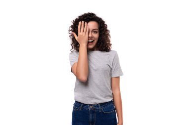 Beyaz arka planda gri, siyah kıvırcık saçlı, bakımlı Avrupalı bir kadın..