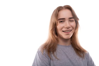 Gri tişörtlü, gülen genç kızın portresi..