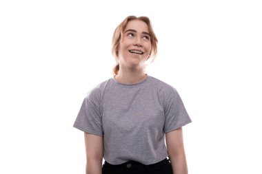 Gri tişörtlü güzel, sarışın genç kız stüdyo geçmişine karşı..