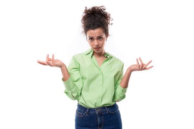 Açık yeşil tişört giymiş genç esmer, kıvırcık saçlı kadın manken, fotokopi alanı olan beyaz bir arka planda şaşkınlık içinde duruyor..