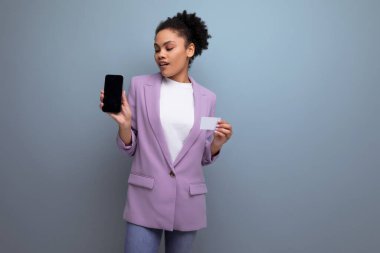 Genç, pozitif, başarılı, saçları dağınık, banka kartı ve telefon tutan Latin bir iş kadını..