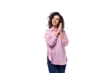 Avrupalı başarılı kıvırcık saçlı, pembe gömlekli, arka planda fotokopi alanı olan bir kadın..