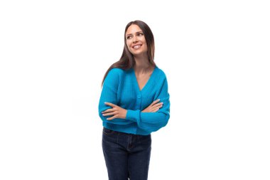 Genç, narin Avrupalı, mavi hırka giymiş, beyaz arka planda düğmeleri olan, fotokopi alanı olan esmer bir kadın..