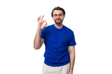 Koyu renk saçlı, sakallı, mavi tişörtlü, yakışıklı, beyaz bir adam..