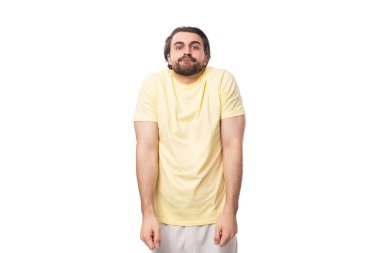 Sakallı ve bıyıklı genç, yakışıklı Avrupalı bir adam. Omuzlarını beyaz bir arka planda silkeliyor..