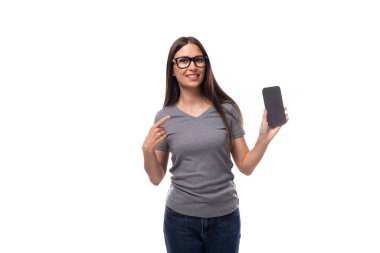 Beyaz tenli, gözlüklü, akıllı telefon ekranı gösteren genç bir kadının portresi..