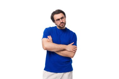 Koyu renk saçlı, mavi tişörtlü, sakallı, kendine güveni olmayan beyaz bir adam şüpheli görünüyor..