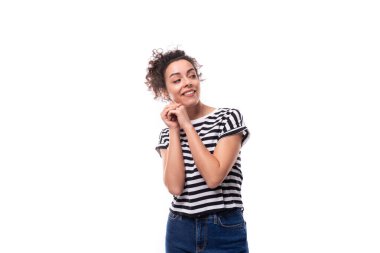 Genç, kıvırcık, siyah saçlı esmer kadın çizgili tişört giyiyor..