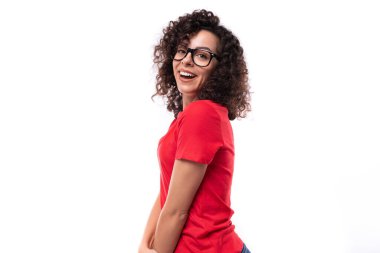 Sıska, genç, kıvırcık esmer kadının portresi. Sıradan kırmızı tişört giyiyor..